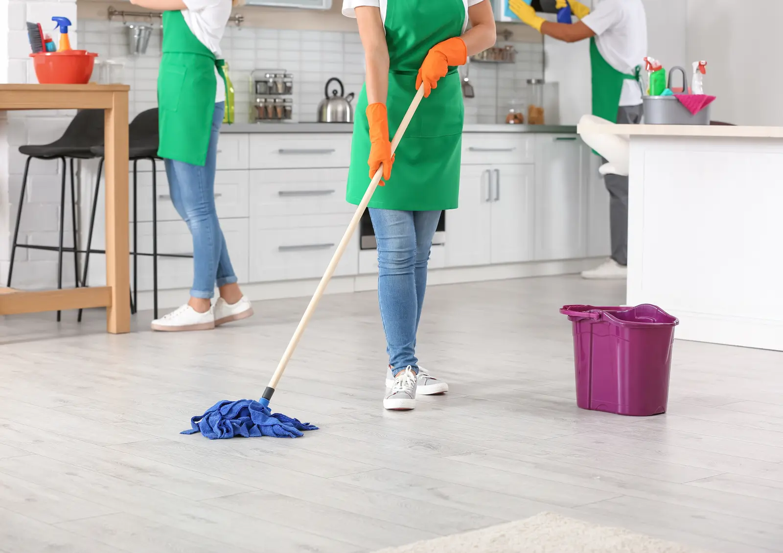 Cleaning team mopping and wiping a modern kitchen