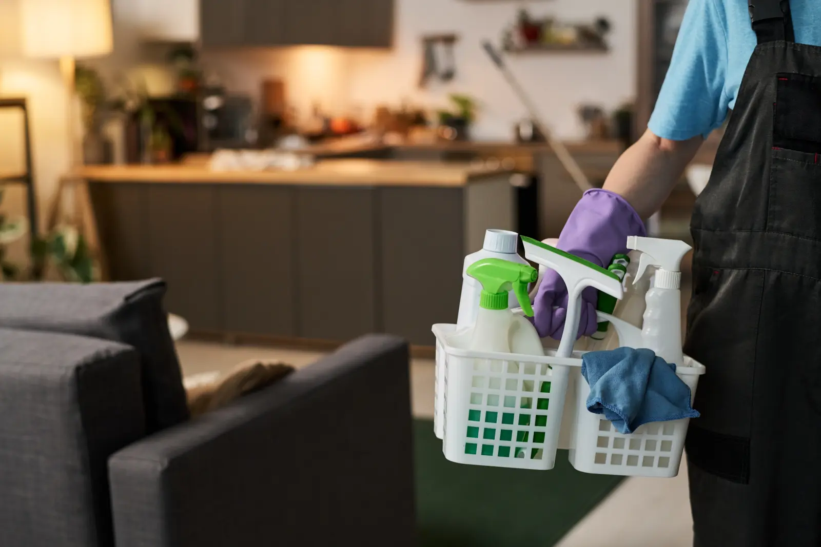 House cleaner carrying a caddy of cleaning supplies