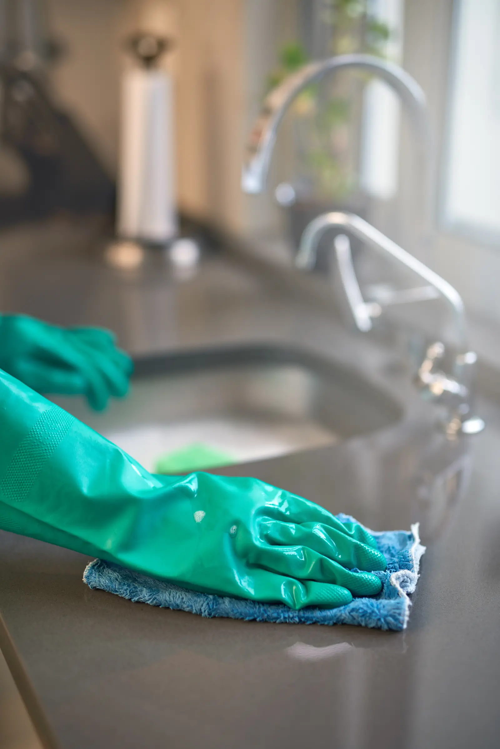 Gloved hand sanitizing a quartz kitchen counter